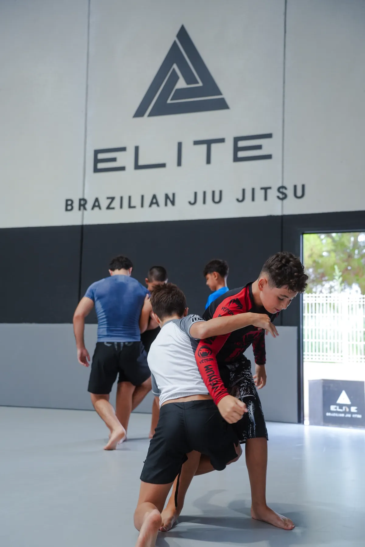 Dos jóvenes practican un derribo en una clase de No-Gi en Elite BJJ, Torrent
