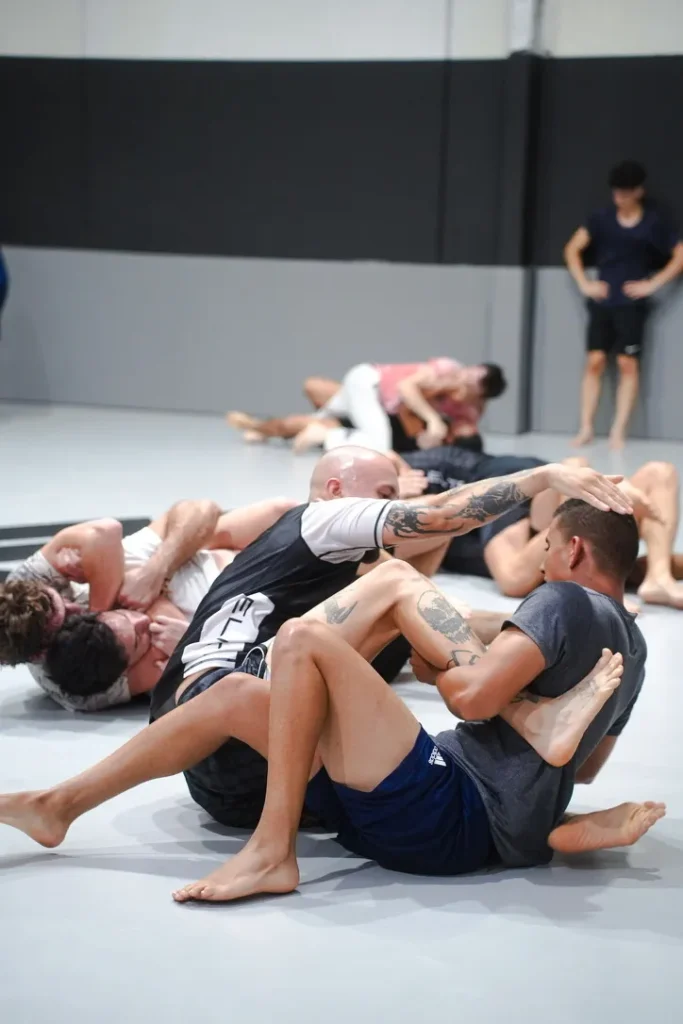 Alumnos de Elite BJJ rodando sin kimono durante una clase de No-Gi