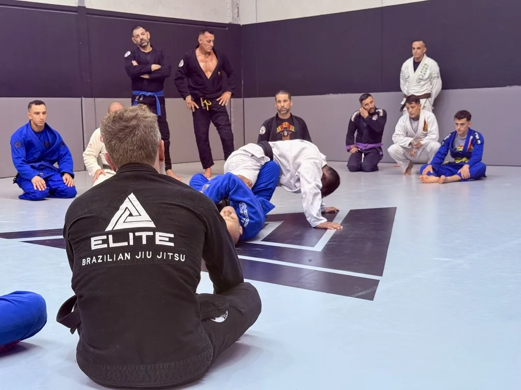 Alumnos de Elite BJJ atentos a una explicación técnica en el tatami de la escuela
